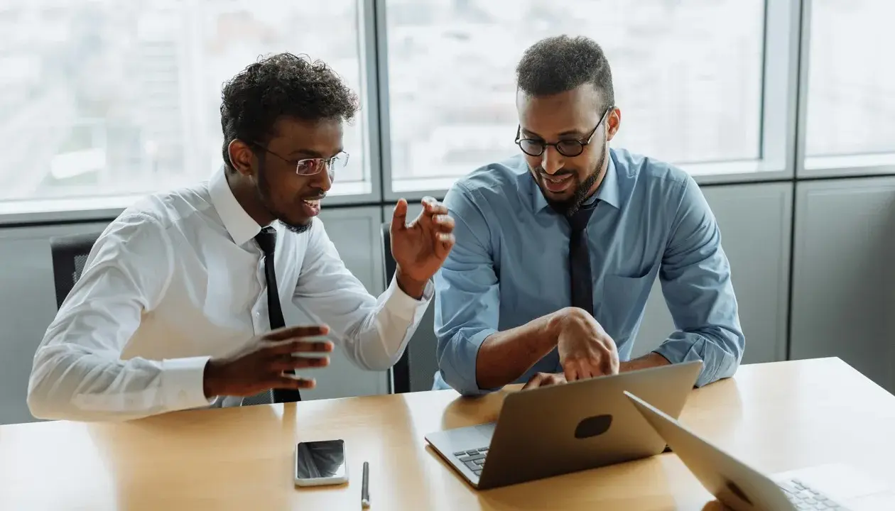 Due professionisti discutono idee per una strategia di comunicazione efficace. Un'agenzia di comunicazione cosa fa? Crea progetti per il successo dei clienti.