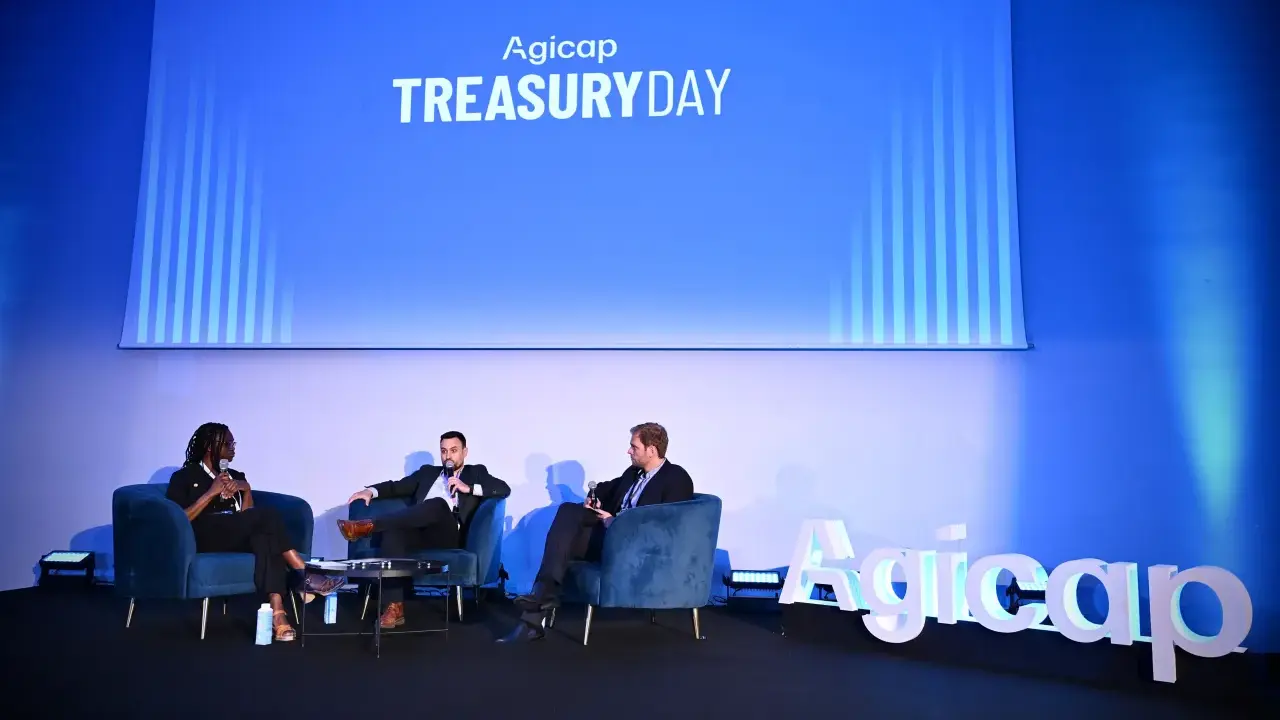 Panel di discussione al Treasury Day Agicap. Un responsabile tesoreria e altri relatori discutono su poltrone blu.