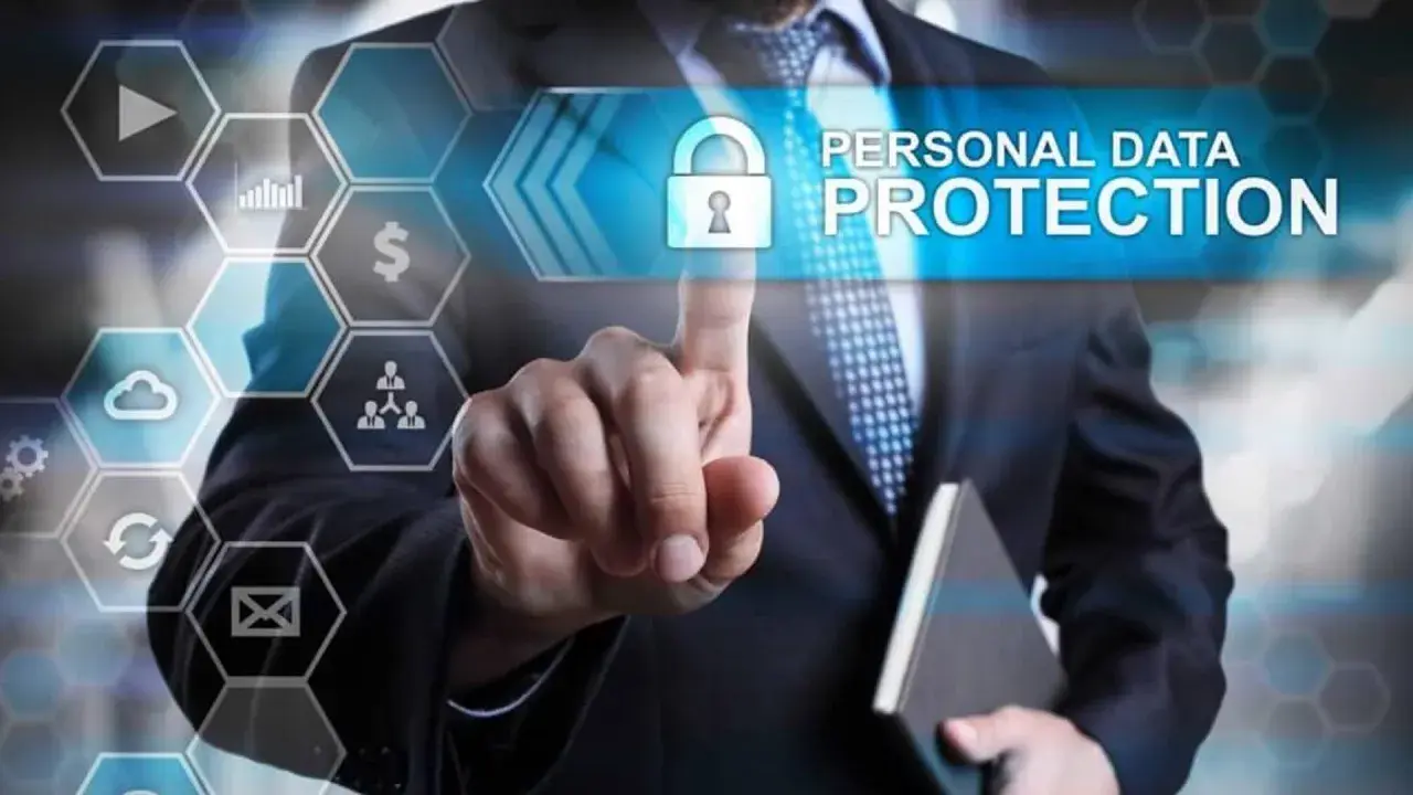 Uomo in giacca e cravatta tocca uno schermo con icone digitali. Il testo "PERSONAL DATA PROTECTION" e un lucchetto indicano la minimizzazione dei dati e la sicurezza.