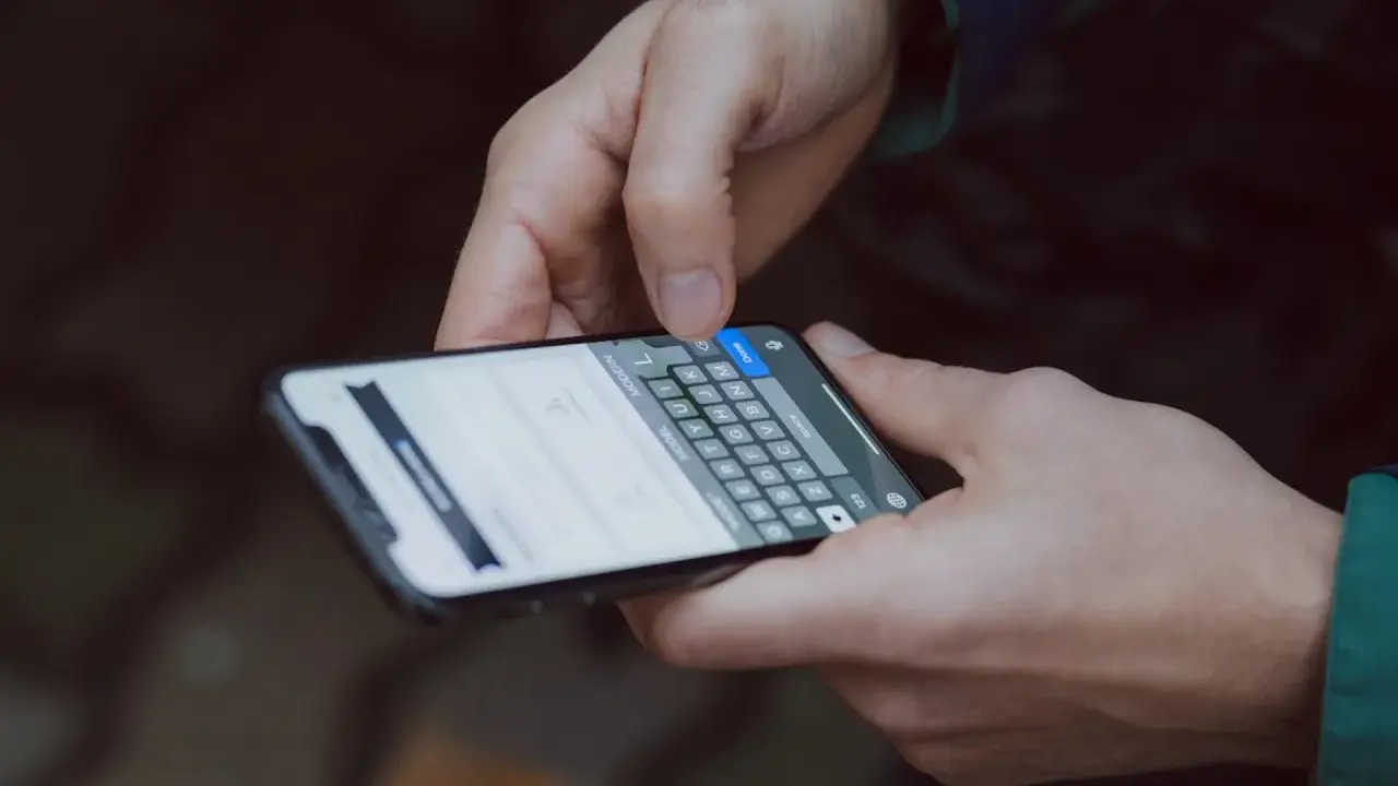 Mani che digitano su uno smartphone, con la tastiera visibile. Come accorgersi di trojan intercettazioni? Attenzione ai segnali insoliti.