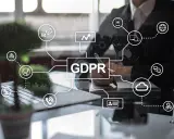 Persona che lavora su un tablet, con un diagramma che mostra il GDPR e icone relative alla privacy e alla tecnologia. La legge privacy in vigore è al centro.