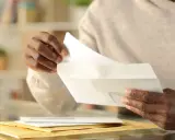 Mani che aprono una busta, attenzione a possibili tentativi di phishing, come un finto esempio di comunicazione da Poste Italiane.