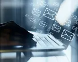 Mani su tastiera di laptop, con tante email e aeroplanini di carta che volano, come un email da me stesso con ricatto.