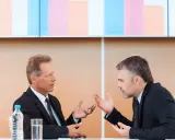 Due uomini d'affari discutono animatamente, mostrando come un business controller analizza dati e strategie per il successo aziendale.