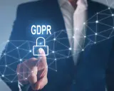 Un uomo in giacca e cravatta tocca un lucchetto stilizzato con la scritta GDPR, simbolo della protezione dei dati personali.