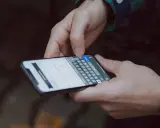 Mani che digitano su uno smartphone, con la tastiera visibile. Come accorgersi di trojan intercettazioni? Attenzione ai segnali insoliti.