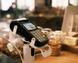 Terminale POS con scontrino stampato, pronto per la chiusura POS obbligatoria a fine giornata.