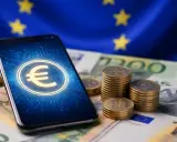 Smartphone con simbolo euro digitale, monete e banconote europee.