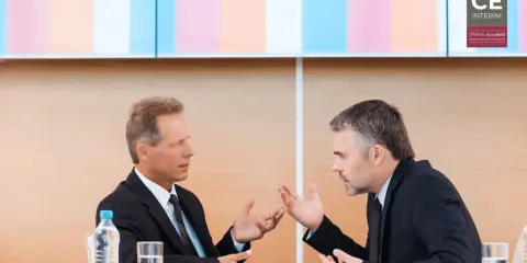 Due uomini d'affari discutono animatamente, mostrando come un business controller analizza dati e strategie per il successo aziendale.