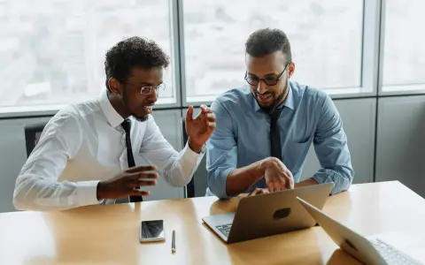 Due professionisti discutono idee per una strategia di comunicazione efficace. Un'agenzia di comunicazione cosa fa? Crea progetti per il successo dei clienti.