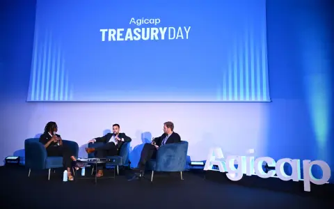 Panel di discussione al Treasury Day Agicap. Un responsabile tesoreria e altri relatori discutono su poltrone blu.