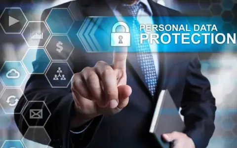 Uomo in giacca e cravatta tocca uno schermo con icone digitali. Il testo "PERSONAL DATA PROTECTION" e un lucchetto indicano la minimizzazione dei dati e la sicurezza.