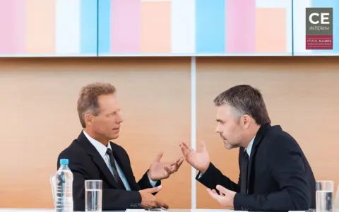 Due uomini d'affari discutono animatamente, mostrando come un business controller analizza dati e strategie per il successo aziendale.