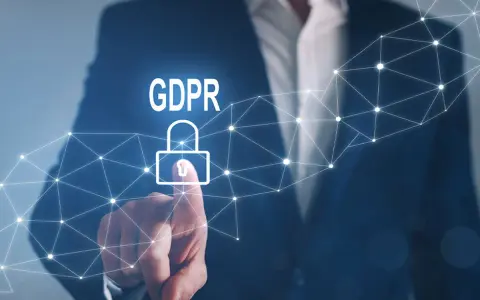 Un uomo in giacca e cravatta tocca un lucchetto stilizzato con la scritta GDPR, simbolo della protezione dei dati personali.