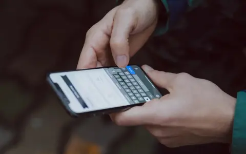 Mani che digitano su uno smartphone, con la tastiera visibile. Come accorgersi di trojan intercettazioni? Attenzione ai segnali insoliti.