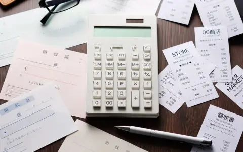Calcolatrice e ricevute sparse, un promemoria visivo di una possibile multa per scontrino non emesso.