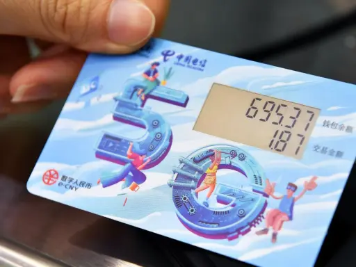 Carta con display mostra saldo e transazione, con icone che celebrano il yuan digitale e la tecnologia 5G.
