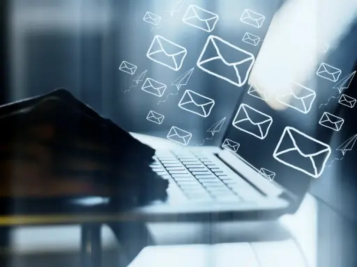 Mani su tastiera di laptop, con tante email e aeroplanini di carta che volano, come un email da me stesso con ricatto.