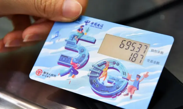 Carta con display mostra saldo e transazione, con icone che celebrano il yuan digitale e la tecnologia 5G.
