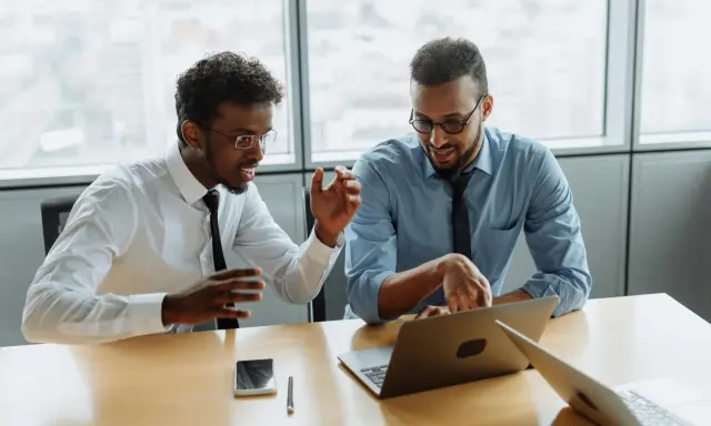 Due professionisti discutono idee per una strategia di comunicazione efficace. Un'agenzia di comunicazione cosa fa? Crea progetti per il successo dei clienti.