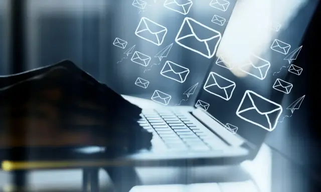 Mani su tastiera di laptop, con tante email e aeroplanini di carta che volano, come un email da me stesso con ricatto.