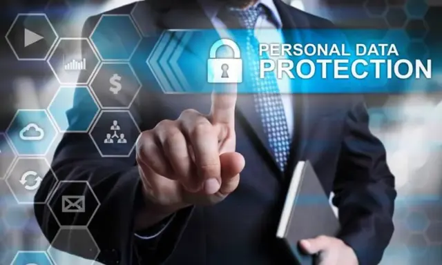 Uomo in giacca e cravatta tocca uno schermo con icone digitali. Il testo "PERSONAL DATA PROTECTION" e un lucchetto indicano la minimizzazione dei dati e la sicurezza.