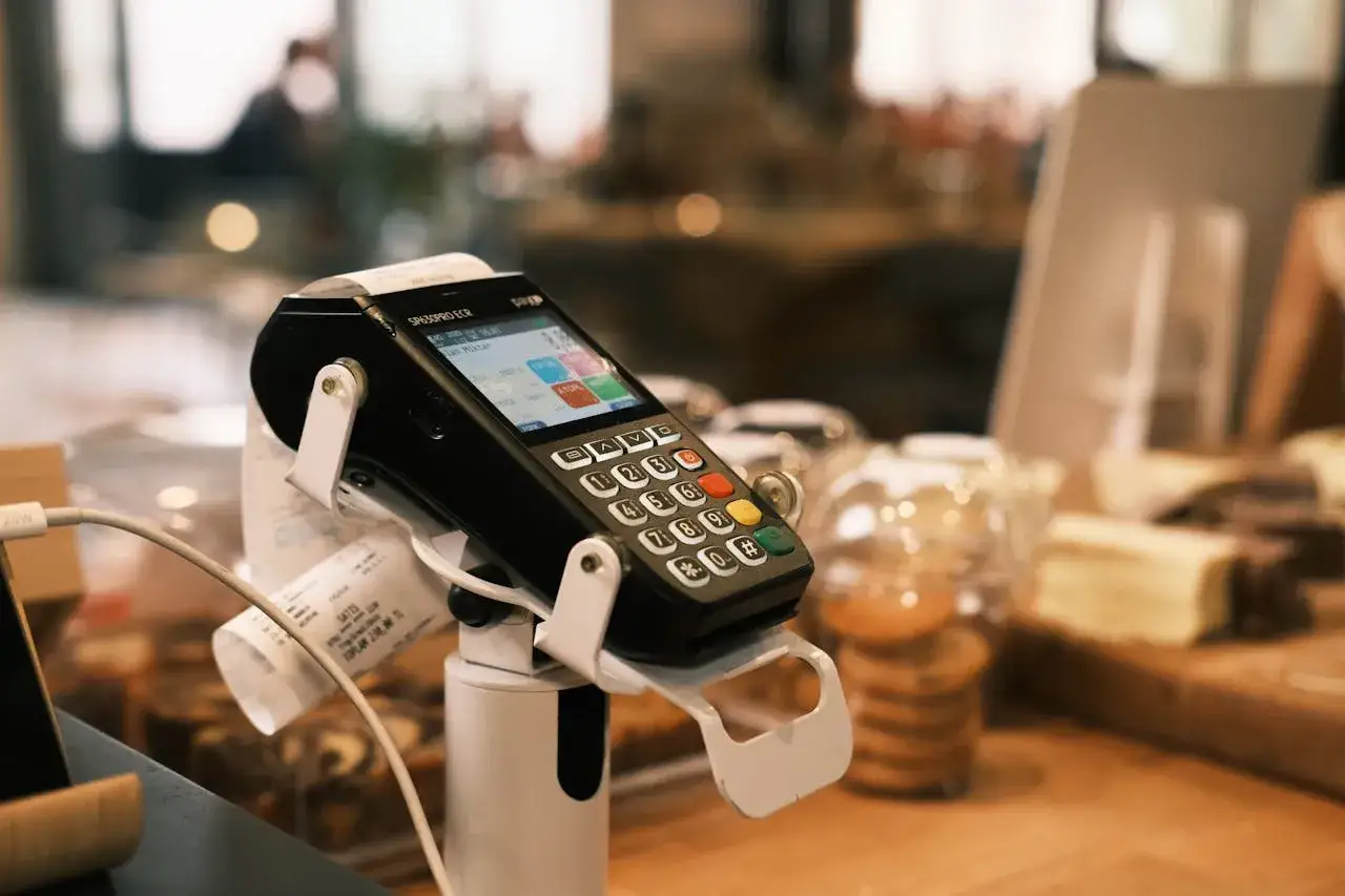 Terminale POS con scontrino, pronto per la chiusura POS obbligatoria a fine giornata.