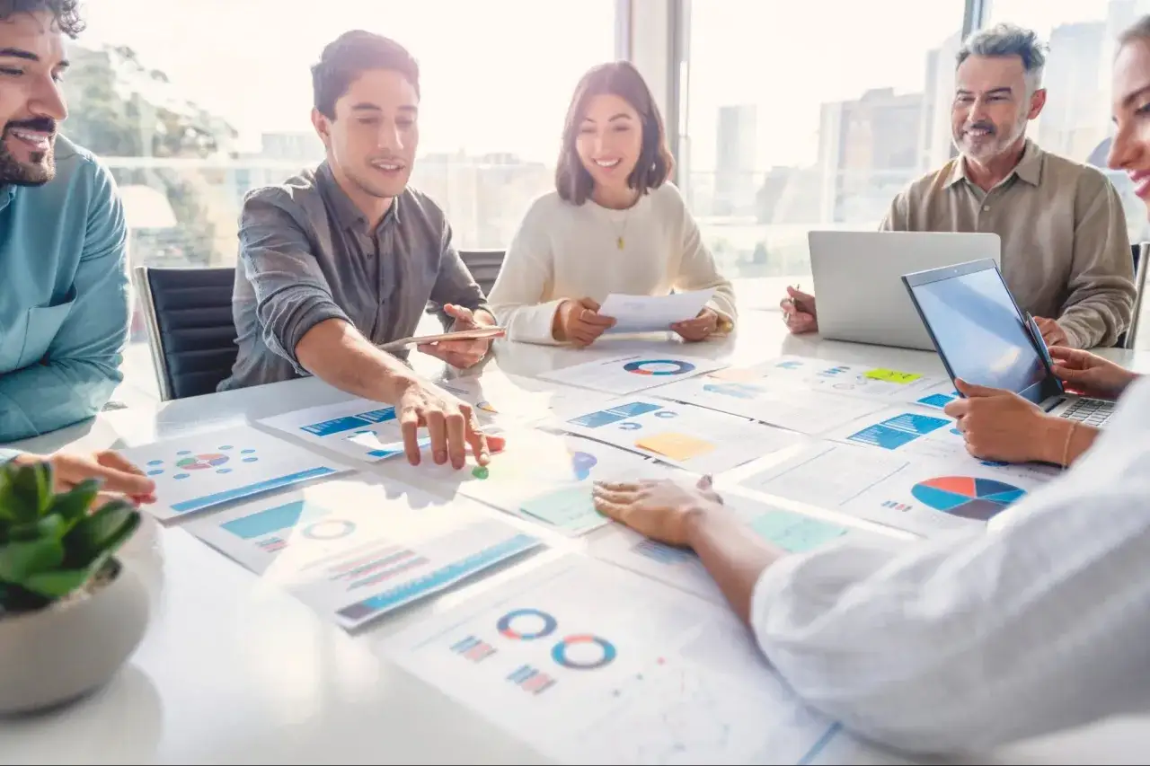 Team discute grafici e report. Un account specialist cosa fa? Analizza dati per strategie di successo.