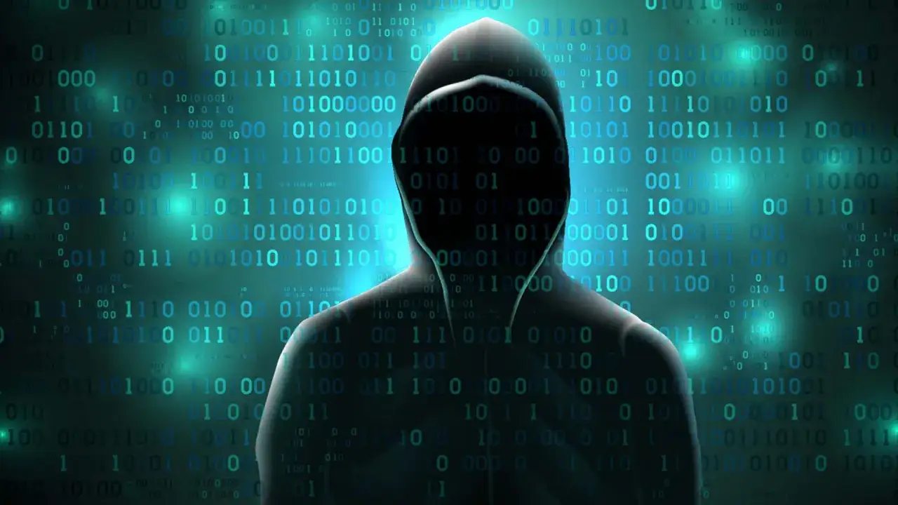 Silhouette di un hacker con cappuccio su sfondo di codice binario. Attenzione alla truffa bitcoin.