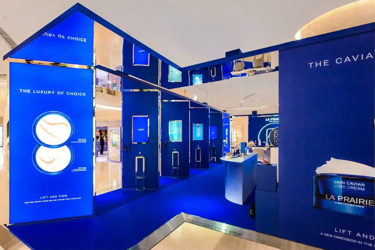 Un'installazione di experiential marketing La Prairie, con pareti blu intenso, specchi e display interattivi che invitano a scoprire la linea Skin Caviar.