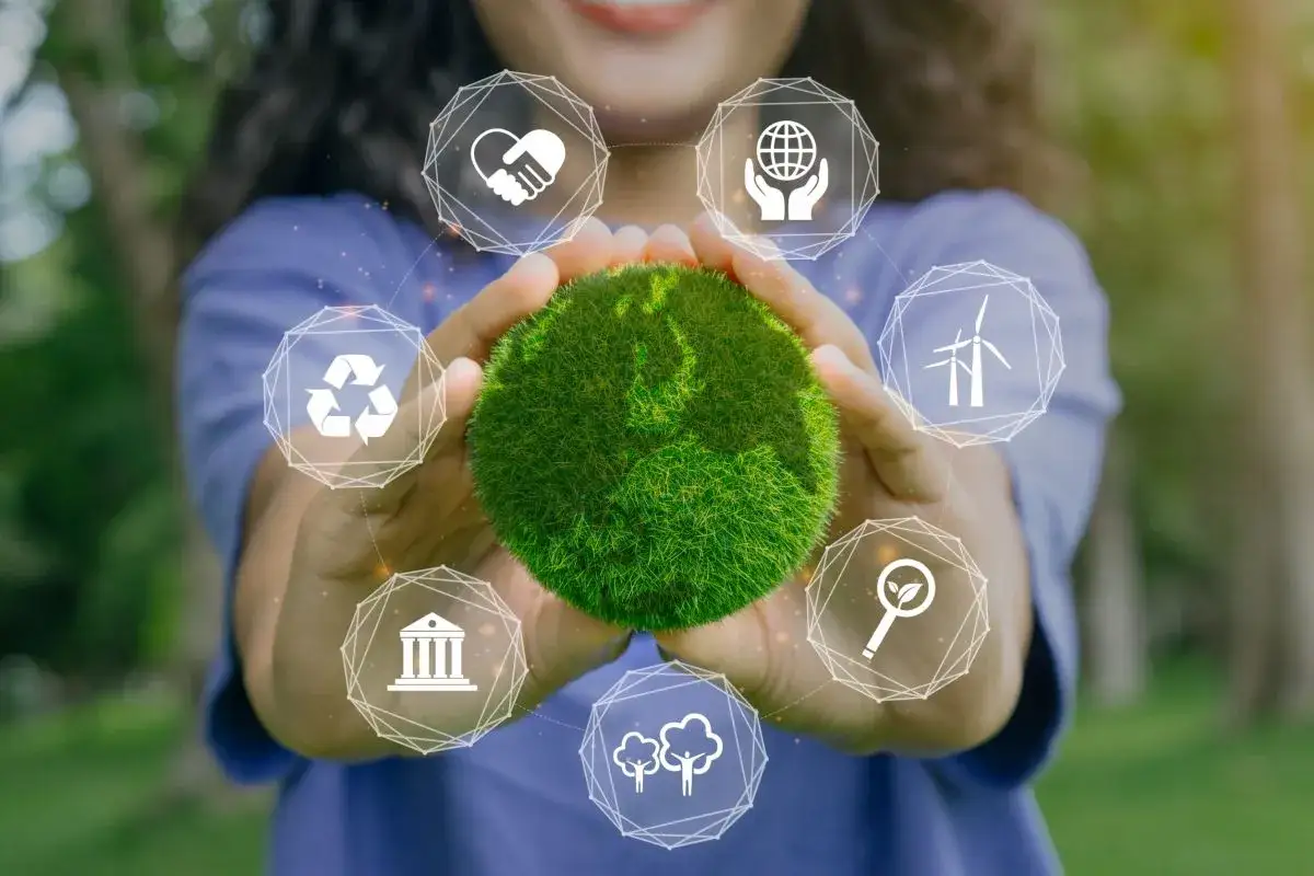 Mani che sorreggono un globo verde, circondato da icone che rappresentano sostenibilità e responsabilità sociale, come in un esempio bilancio di sostenibilità.